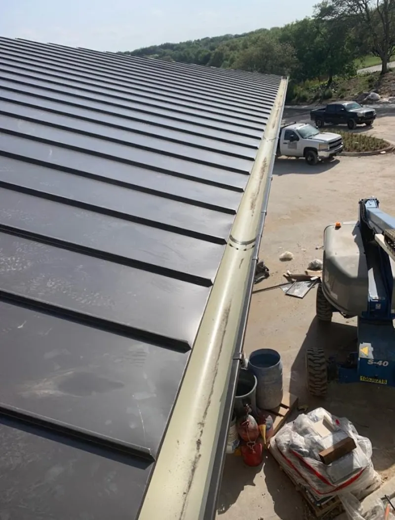 Standing seam panel and gutter detail on a metal roofing jobsite in Hillside
